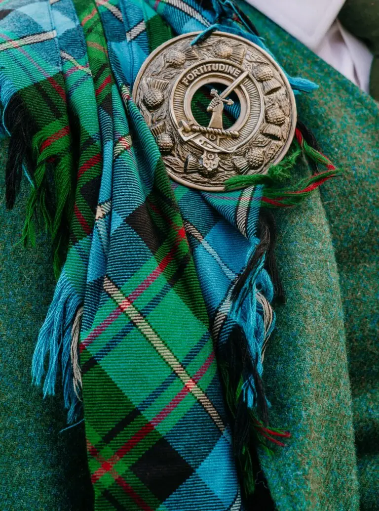 Schotse tartan en clan-broche als trouwdetail, bruidsfotografie door Indra Hunze
