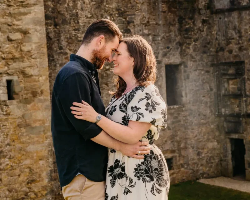 Koppel omhelst elkaar bij een kasteelruïne, ongeposeerde fotografie door Indra Hunze