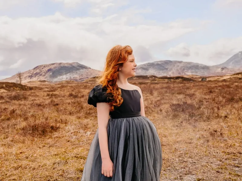 Kind in een tule jurk in een weids landschap, gezinsfotografie door Indra Hunze