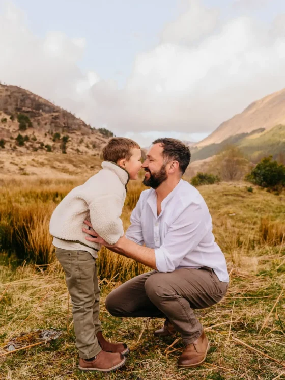 Vader en zoon neus aan neus in een open landschap, gezinsfotografie door Indra Hunze