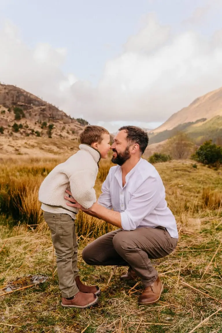 Vader en zoon neus aan neus in een open landschap, gezinsfotografie door Indra Hunze