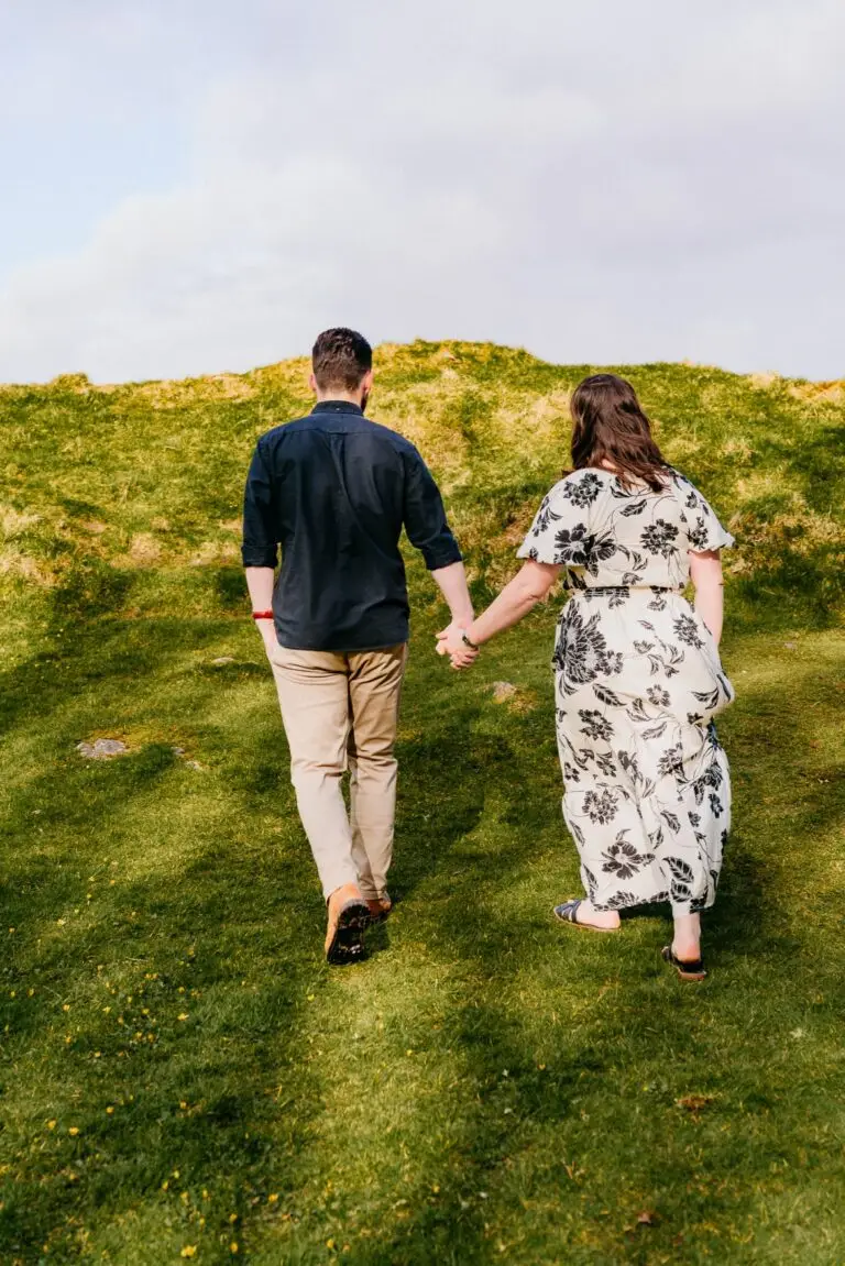 Koppel hand in hand wandelend door het landschap, tijdloze fotografie door Indra Hunze
